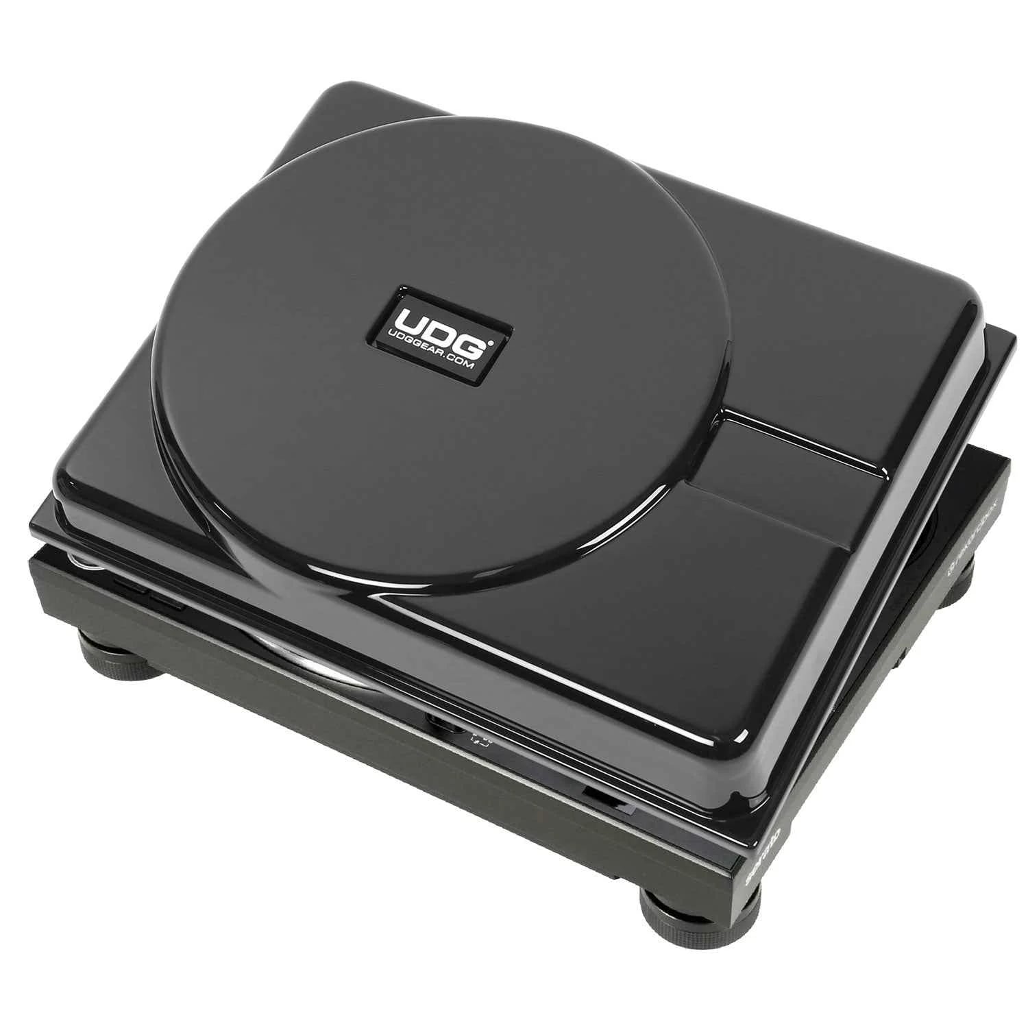 Glossy black UDG decksaver cover with circular logo on top of DJ equipment against white background.